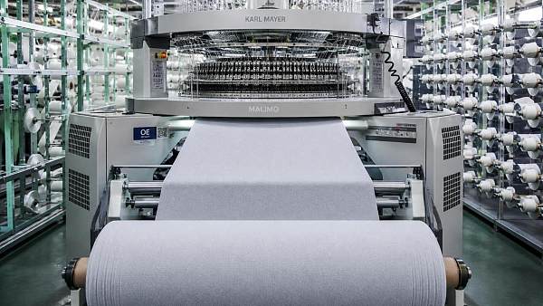 When do tricot knitting machines make sense for stretch fabric production?