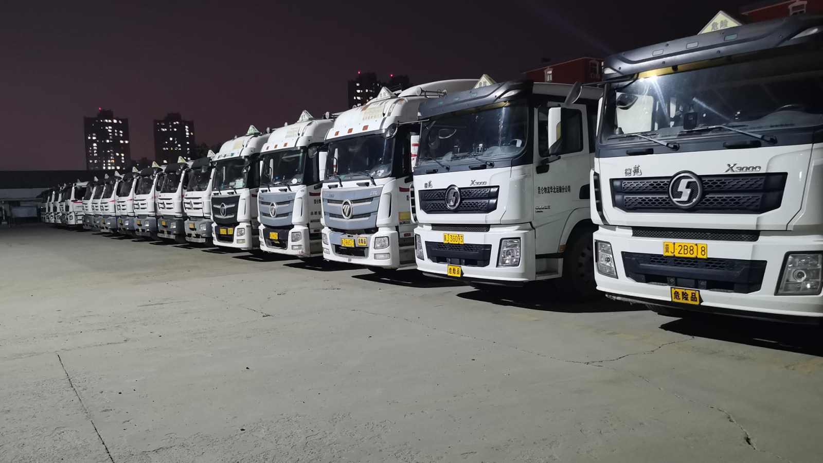 Tanker truck fleet parked at a crude oilfield facility for integrated monitoring and security.
