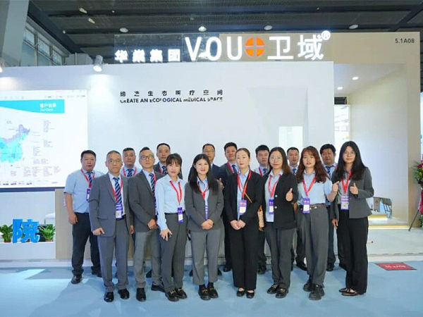 Group photo of sales medical furniture brand team in front of VOUPLUS booth at the China Hospital Construction Conference