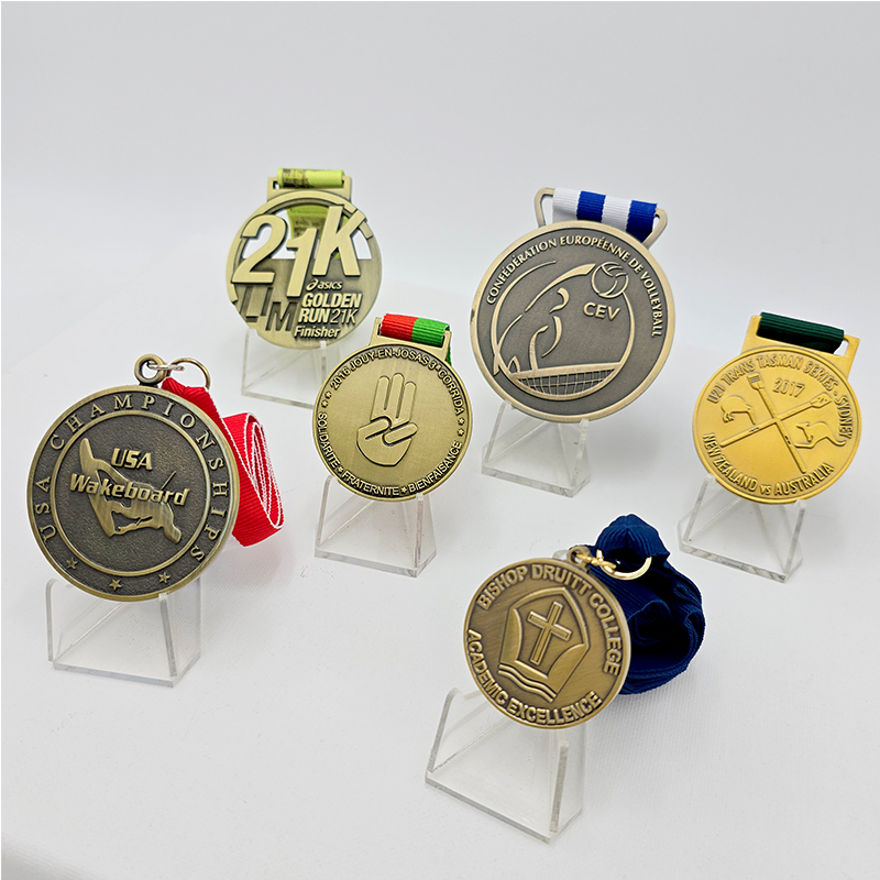 A collection of metal medals in various styles, covering events such as running, volleyball, and waterskiing. Featuring a vintage gold, silver, and bronze finish, these are collectible commemorative items for sporting events.