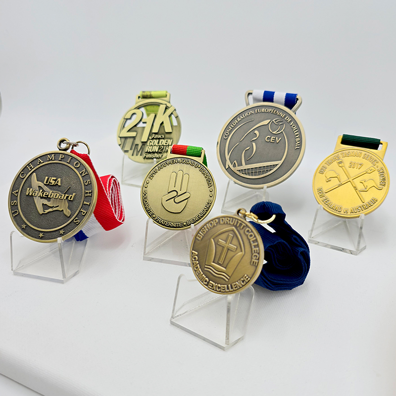 A collection of metal medals in various styles, covering events such as running, volleyball, and waterskiing. Featuring a vintage gold, silver, and bronze finish, these are collectible commemorative items for sporting events.