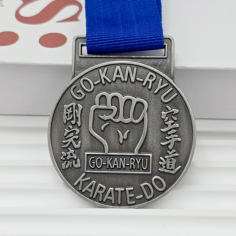 Retro silver metal medal with 3D fist relief, commemorative collectible item for karate-themed events.