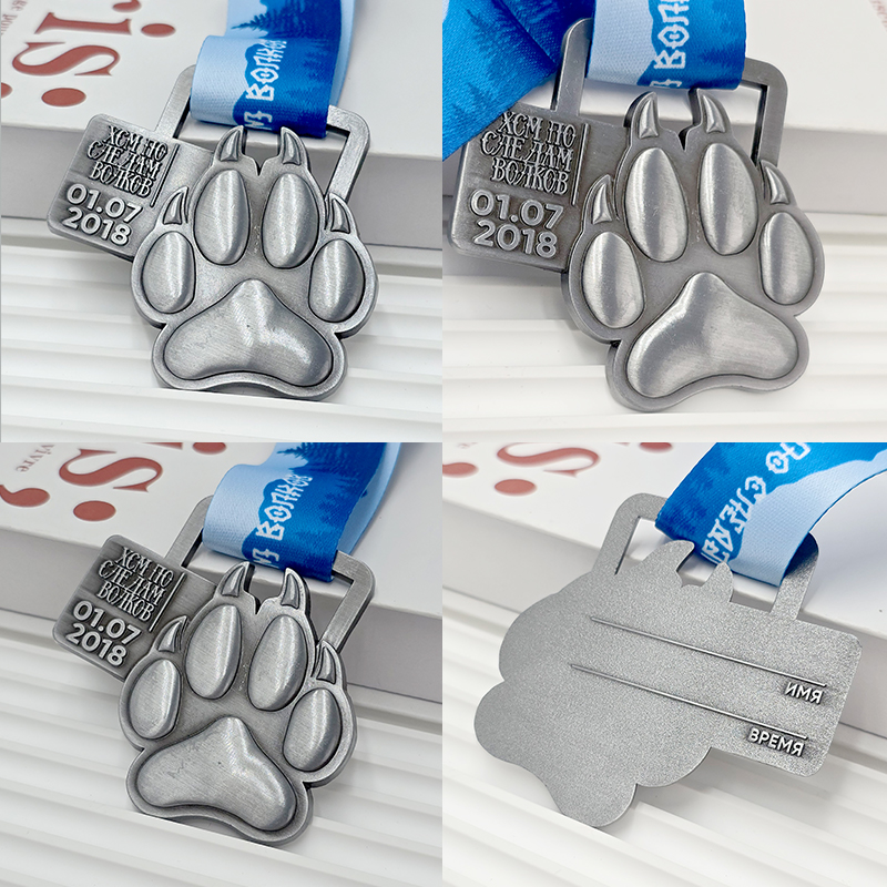 Frosted silver metal medal with bear paw design, commemorative event item, 3D paw print relief, outdoor sports collectible.