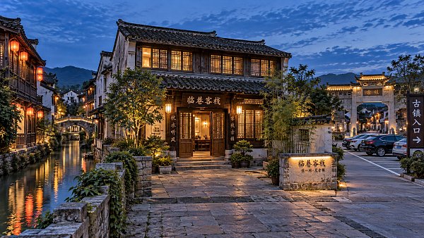 When visiting an ancient town, is it better to stay inside or outside the scenic area?