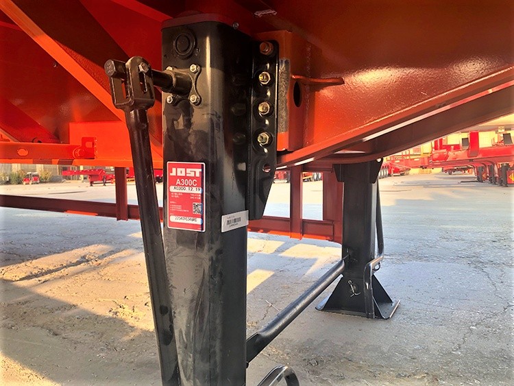 Detalle de las patas de apoyo de un semirremolque portacontenedores de plataforma plana de 40ft y 3 ejes, mostrando el sistema de soporte de alta resistencia Cómo elegir un remolque plataforma para contenedores con alta capacidad de carga