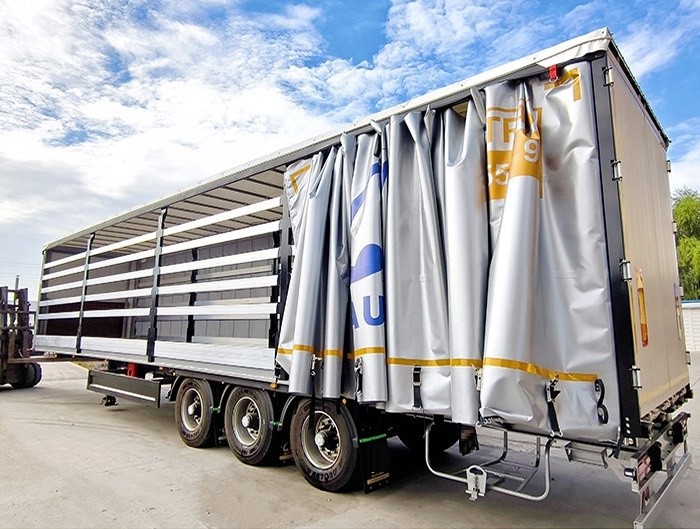 Dry van curtain semi trailer side view showing long cargo deck and enclosed dry van curtain panels Remolque de Cortina para Carga a Granel y General