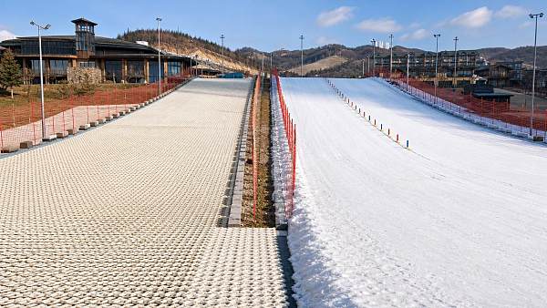 Artificial snow mats vs real snow for beginner ski zones