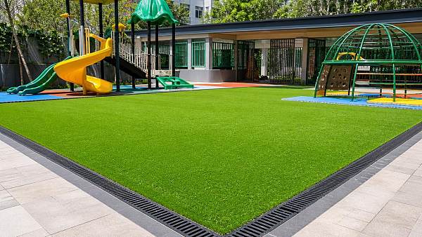 Artificial grass for playground: better drainage, fewer closures?