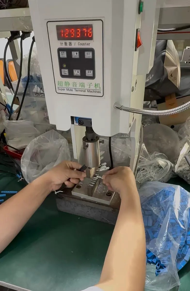 Technician mechanically crimping drop cable connector assemblies at LinkFiber Technician mechanically crimping drop cable connector assemblies at LinkFiber