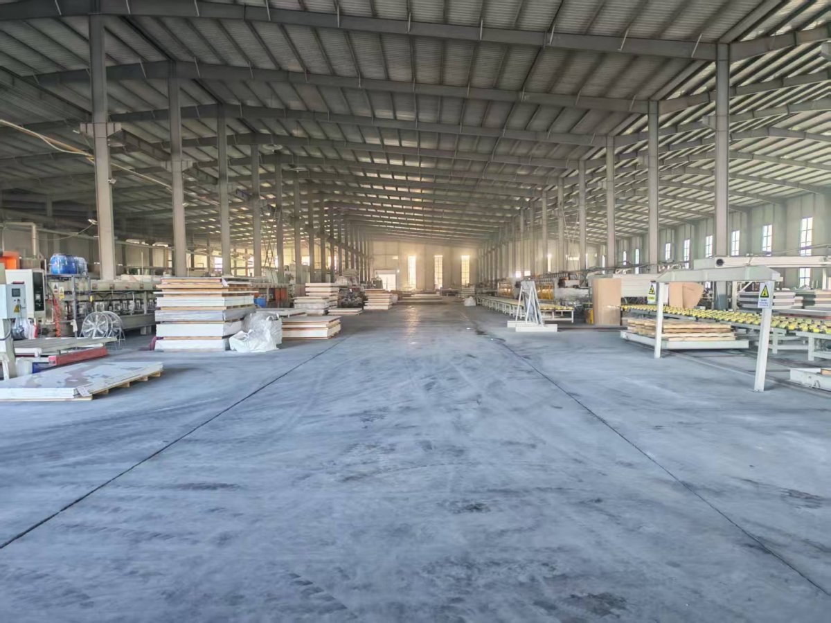 Inside a quartz slab factory with enclosed production lines and slab storage